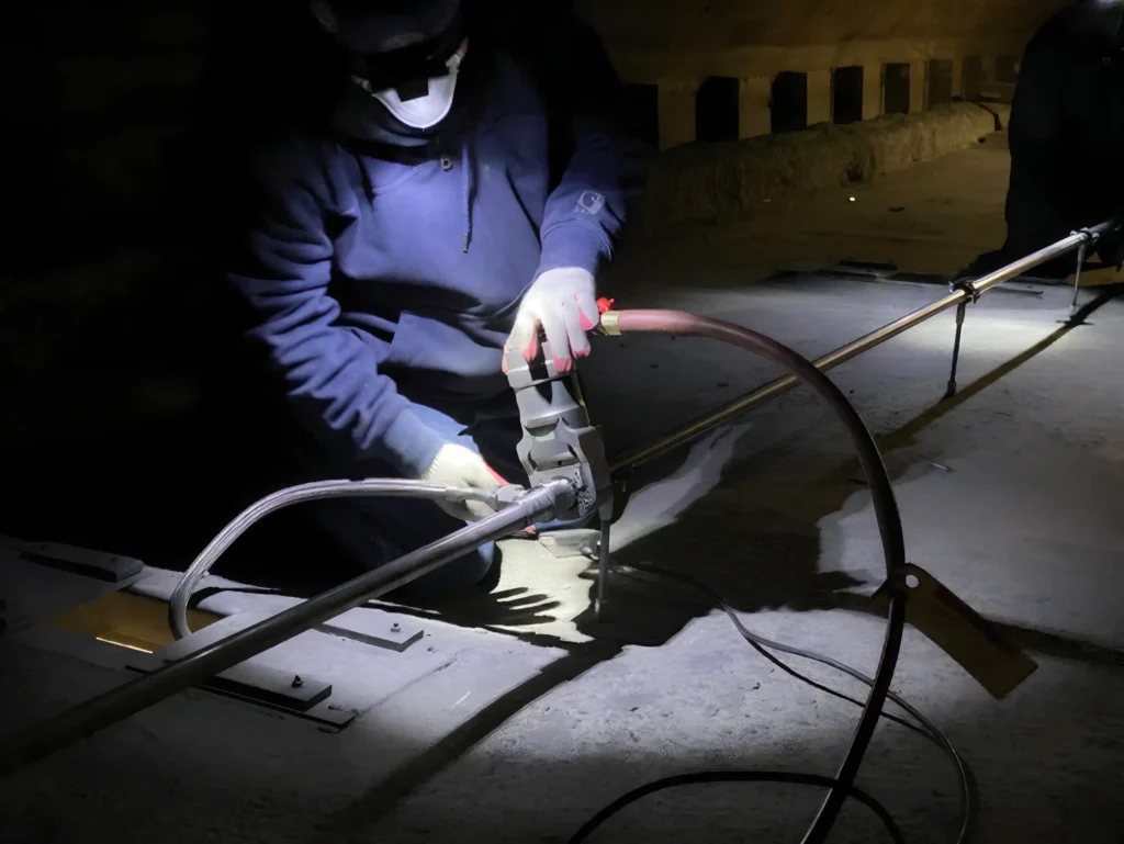 Technician crimping Pyplok® fitting onto water mist piping in Brooklyn Tunnel, New York